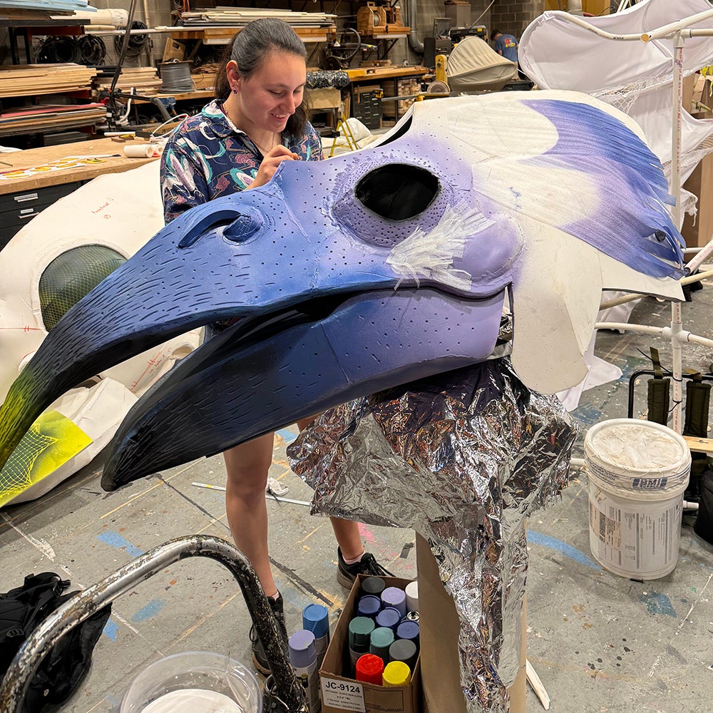 student painting bird creature head