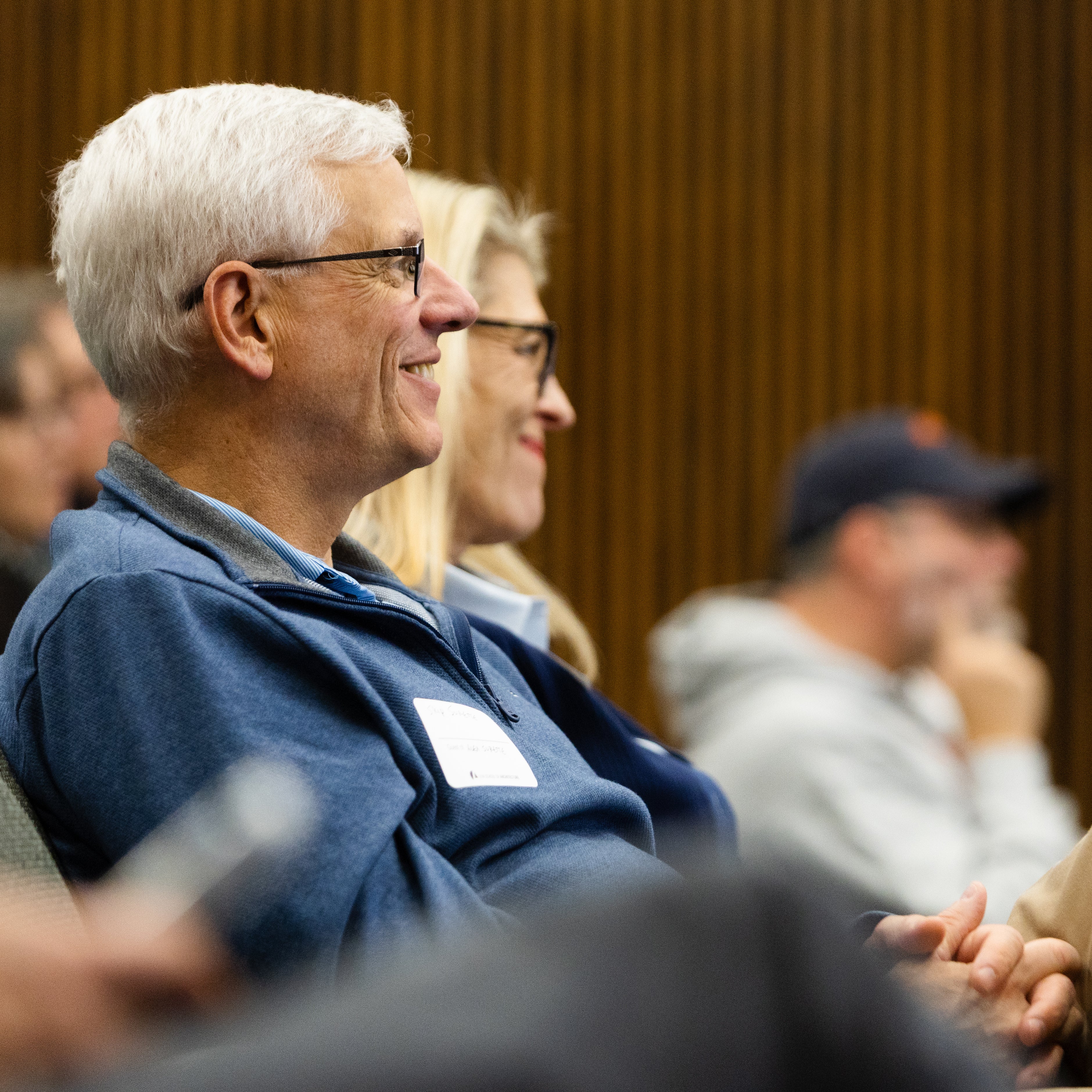 Middle-aged smiling couple in a seated audience 