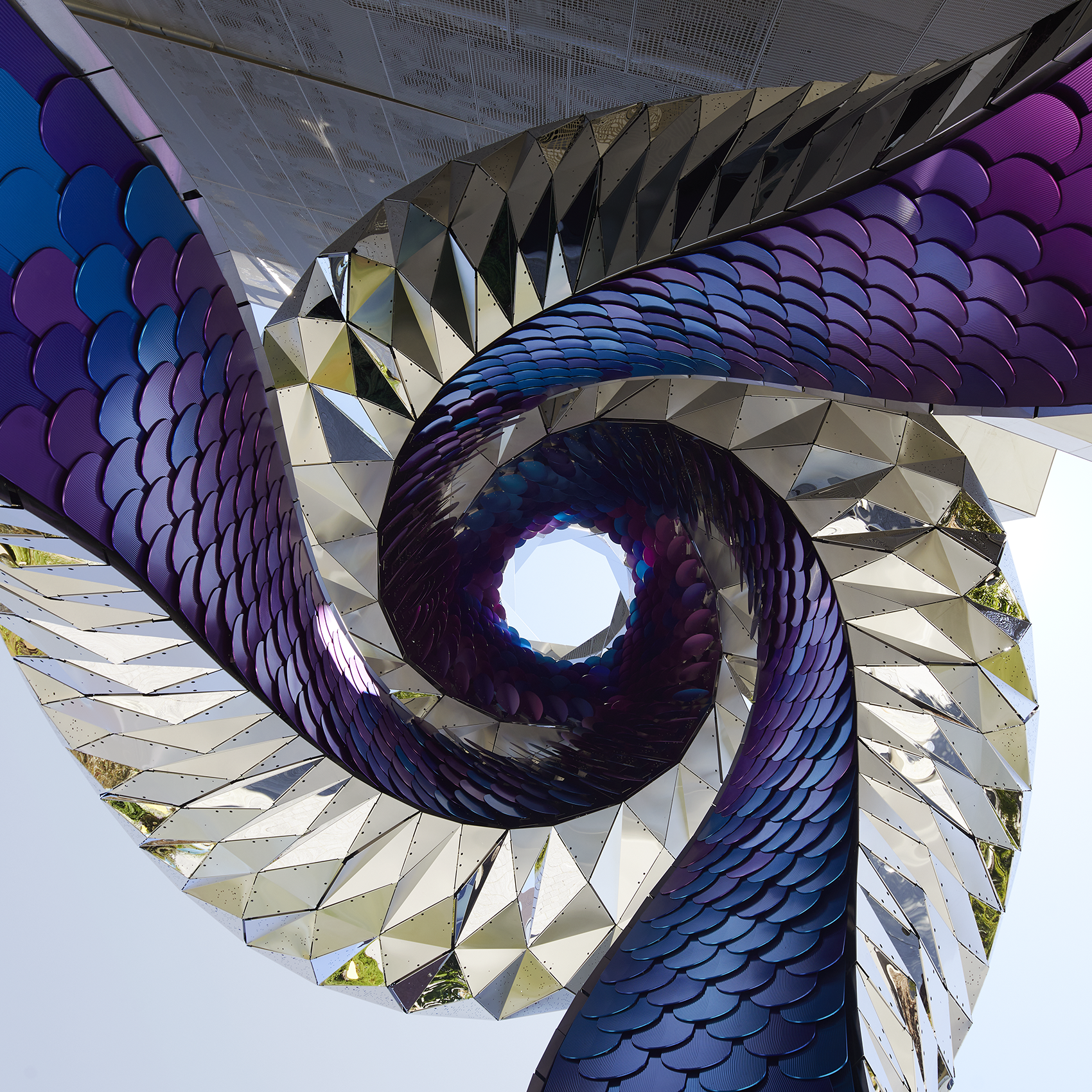 Stainless steel and aluminum sculpture with purple and silver spiraling arms.
