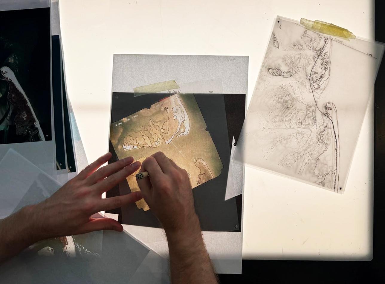 Image of view from above looking down at hands drawing - drawings are of shoal dynamics
