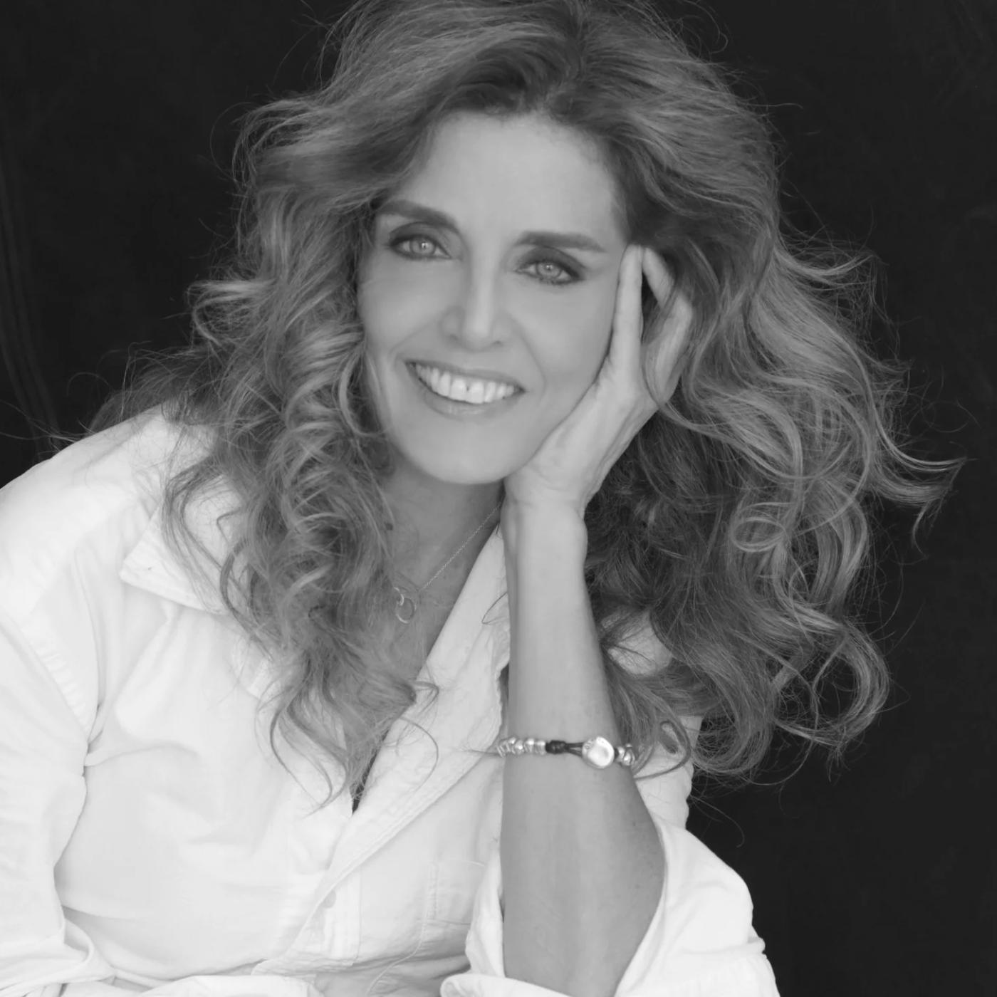 black and white portrait of woman with long wavy hear wearing a white buttoned down shirt