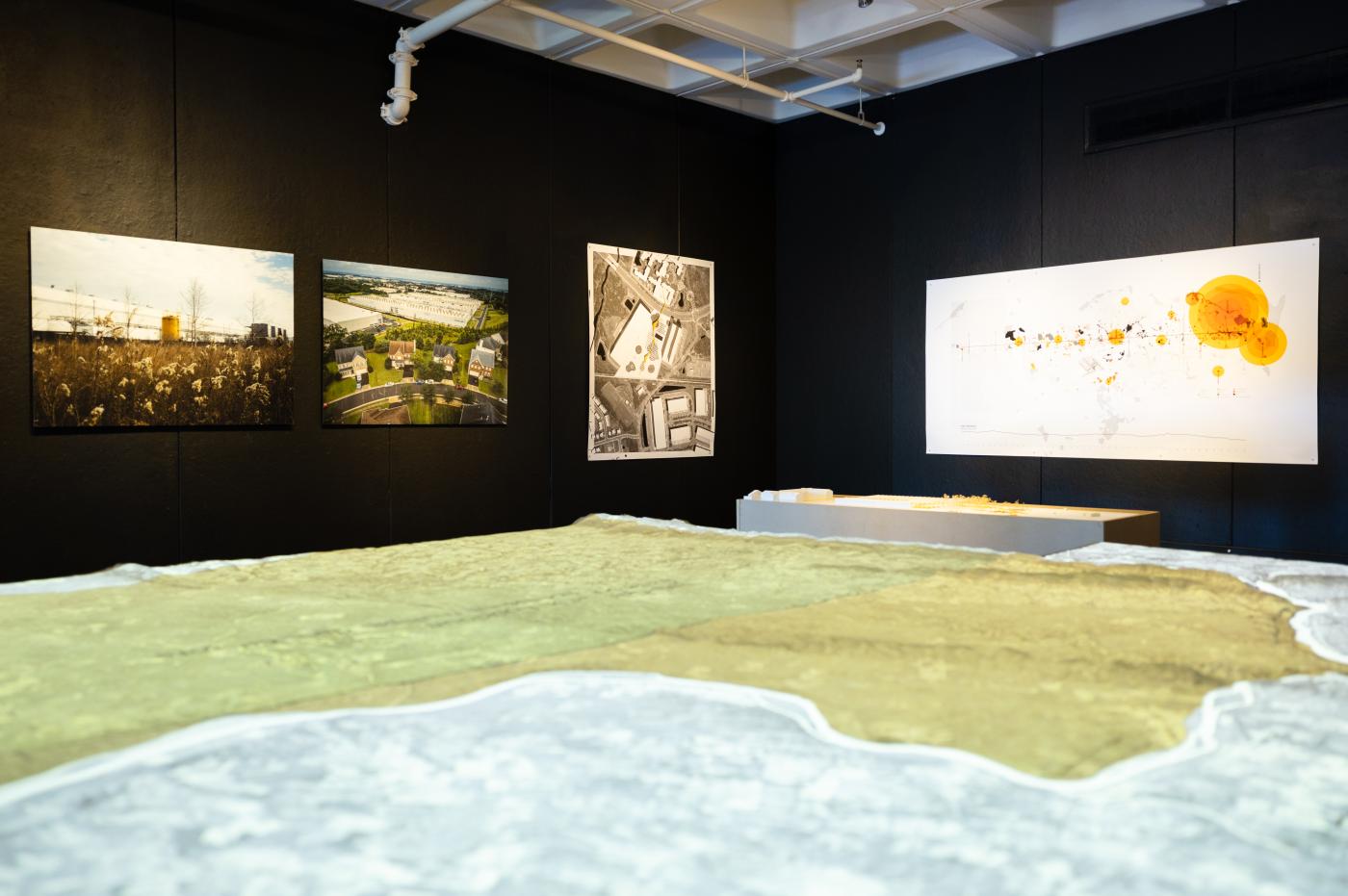 Exhibition in Elmaleh Gallery - Work of MIST lab - overview image of central model of topography and background photographs of North VA data center landscapes