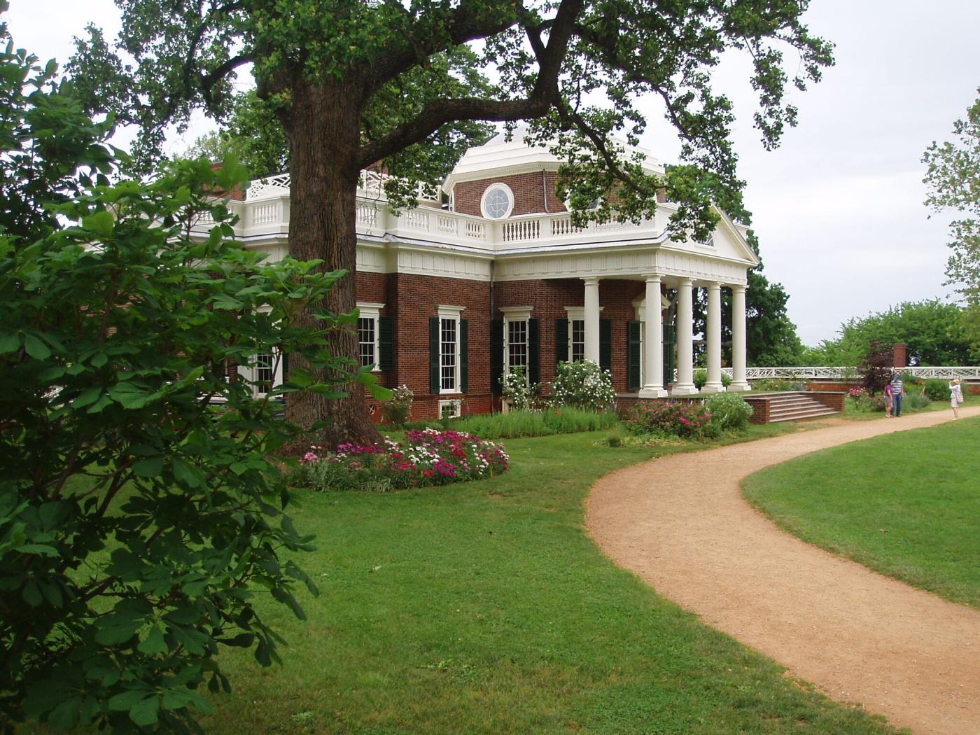 Path leading to historic brick building with white columns.